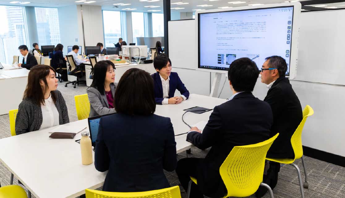 ミーティングスペースで打ち合わせをする社員